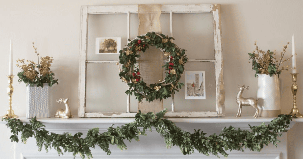 A mantle decorated for christmas with a garland and wreath.