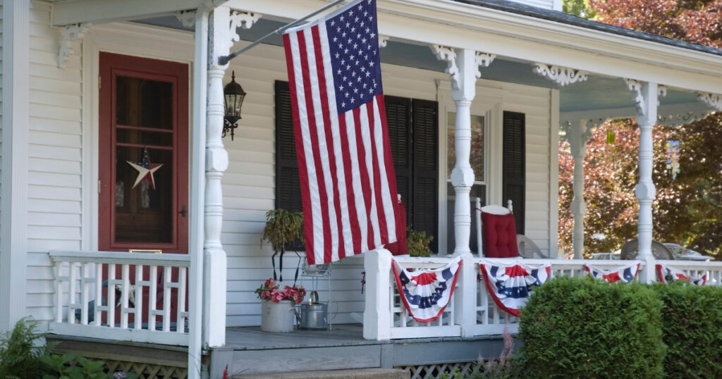 Front porch decorated for Independence Day with flags and bunting